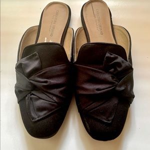 Black satin mules with large bow.